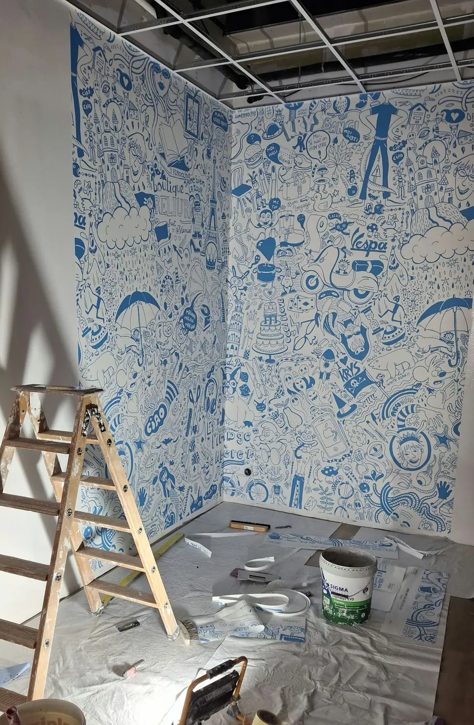 Pose du papier peint à motifs bleus, sol protégé