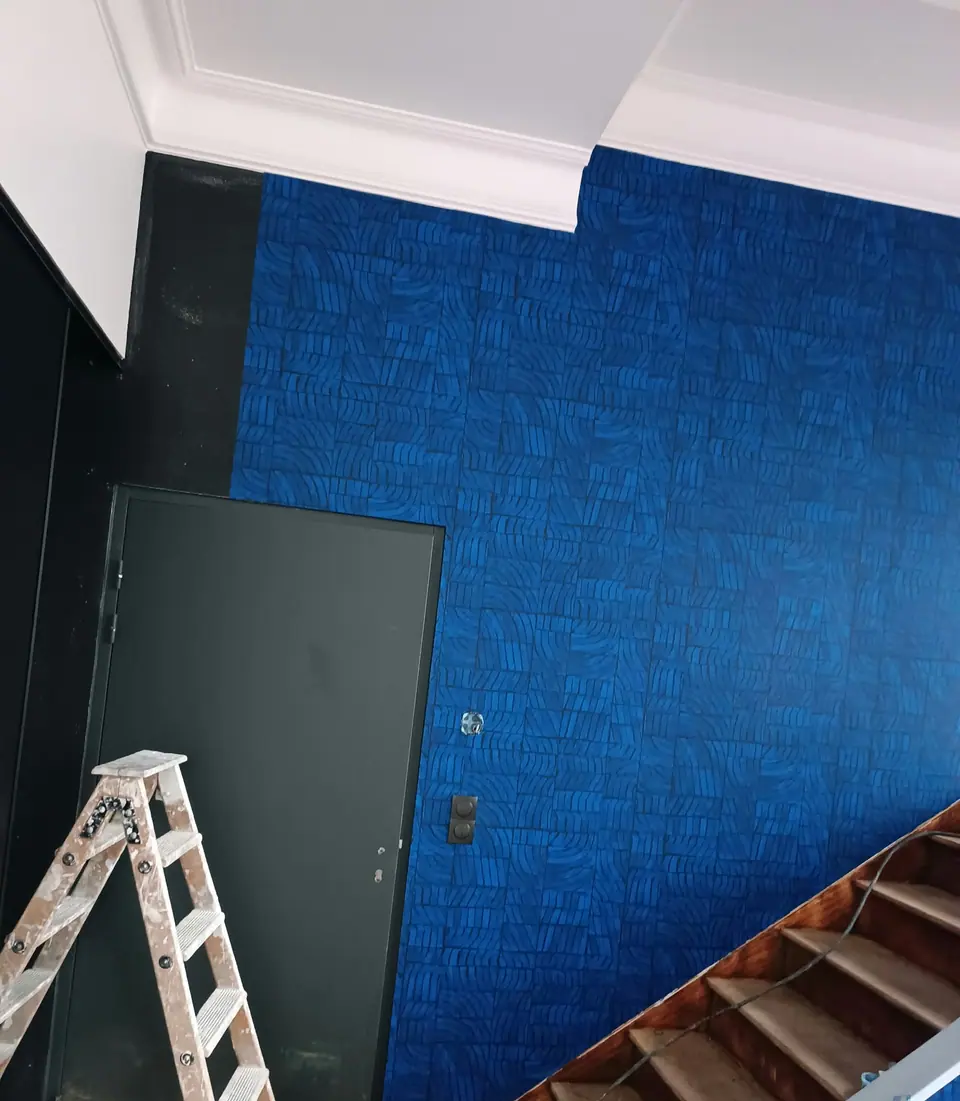 Pose du papier peint bleu autour d'une porte