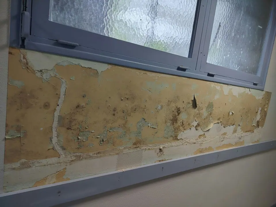 Avant travaux : enduit décollé sous une fenêtre