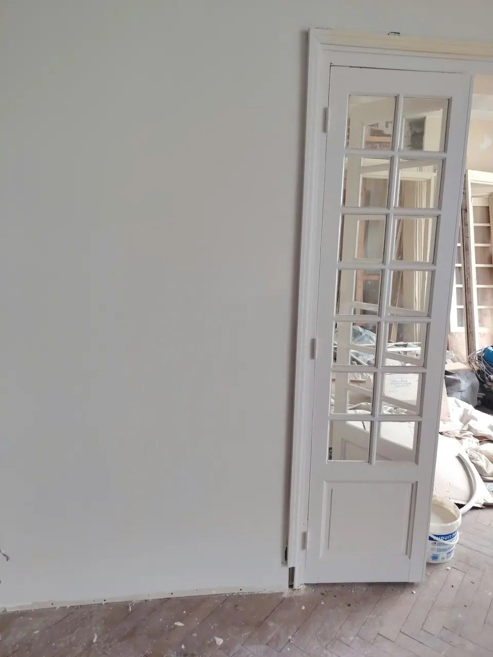 Pièce repeinte en blanc, porte vitrée