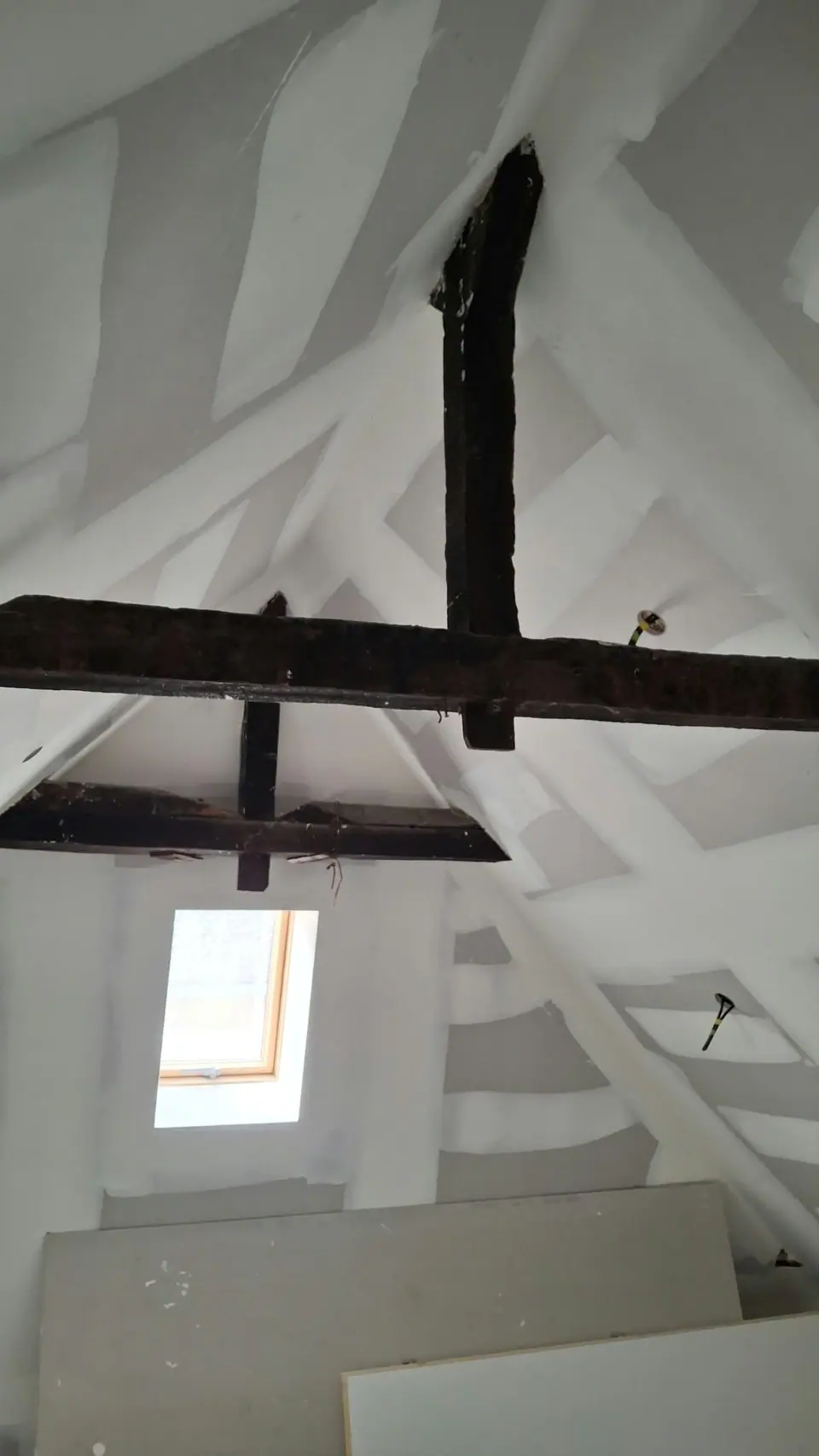 Combles : charpente apparente et plafond enduit