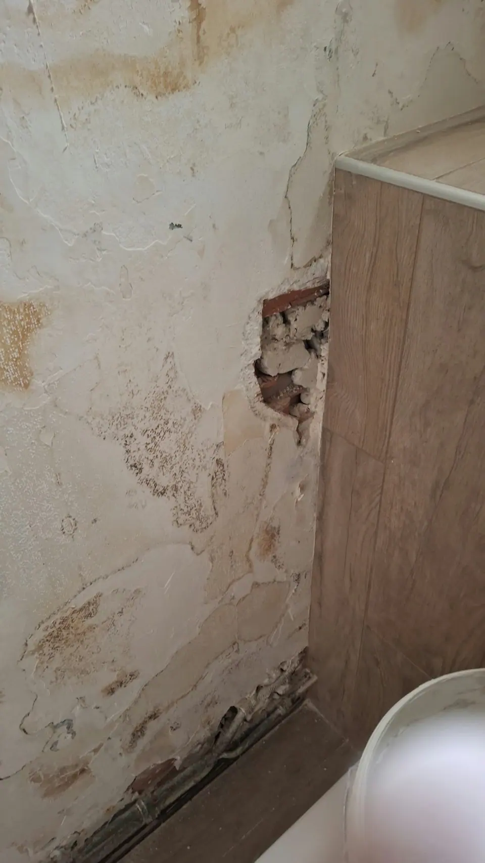 Avant travaux : mur dégradé derrière un meuble
