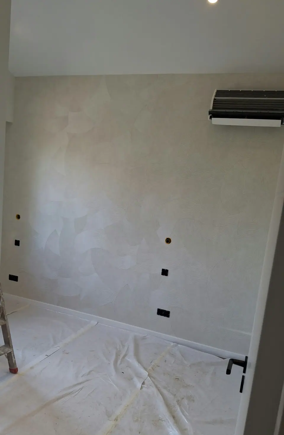 Mur rebouché à l'enduit, sol protégé
