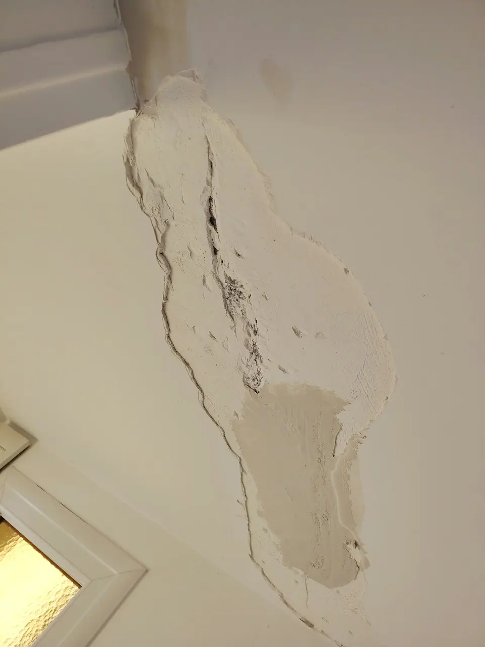 Fissure ouverte et rebouchée au-dessus d'une porte