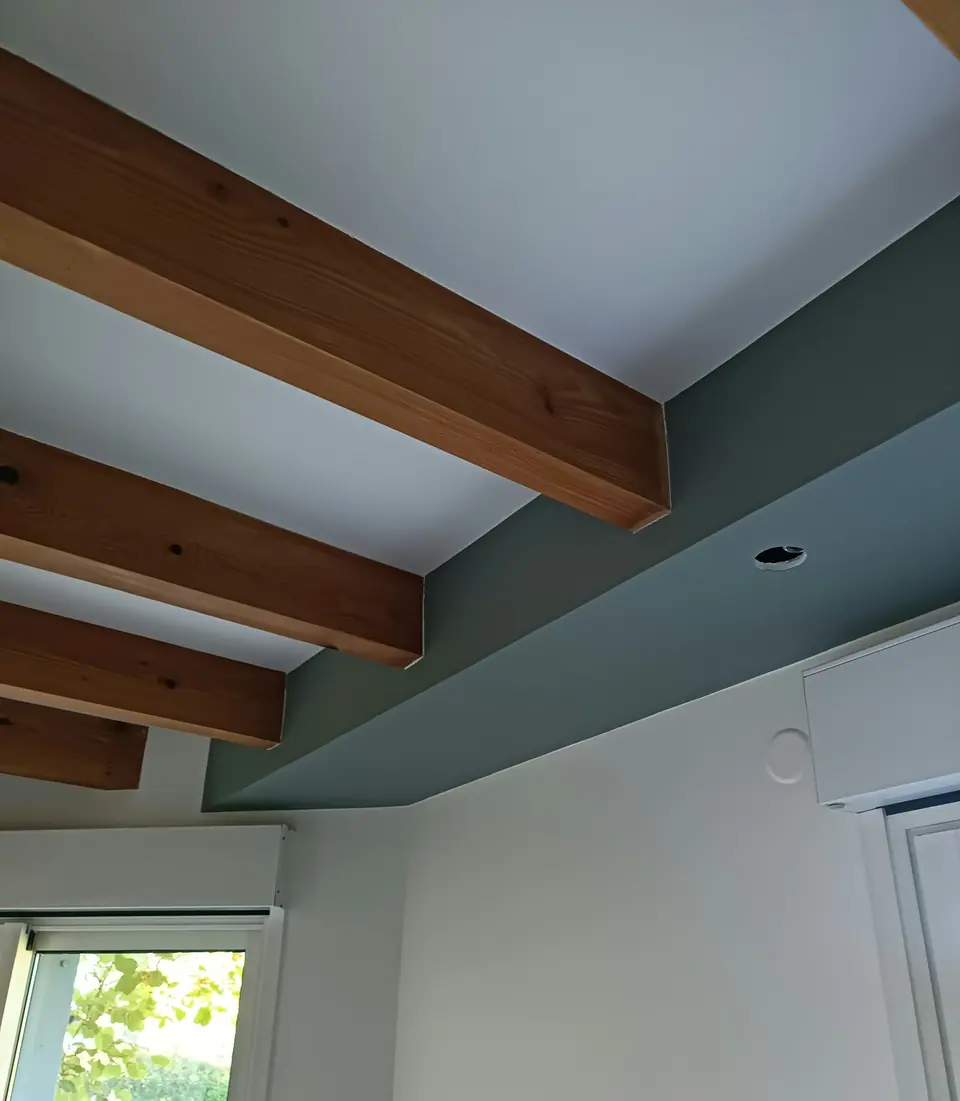 Plafond blanc, poutres et bandeau vert d'eau